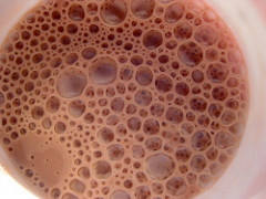 Foaming glass of chocolate milk seen from the top